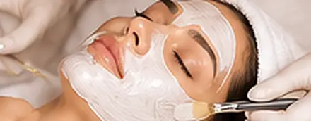 Client relaxing with a white Casmara mask being applied by brush